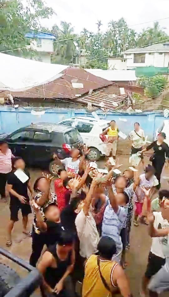 In this screen grab from a viral video, pandemonium ensues as cash notes ‘rain down’ from a balcony, sparking a frenzied scramble below.